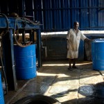 man standing by barrels in dharavi